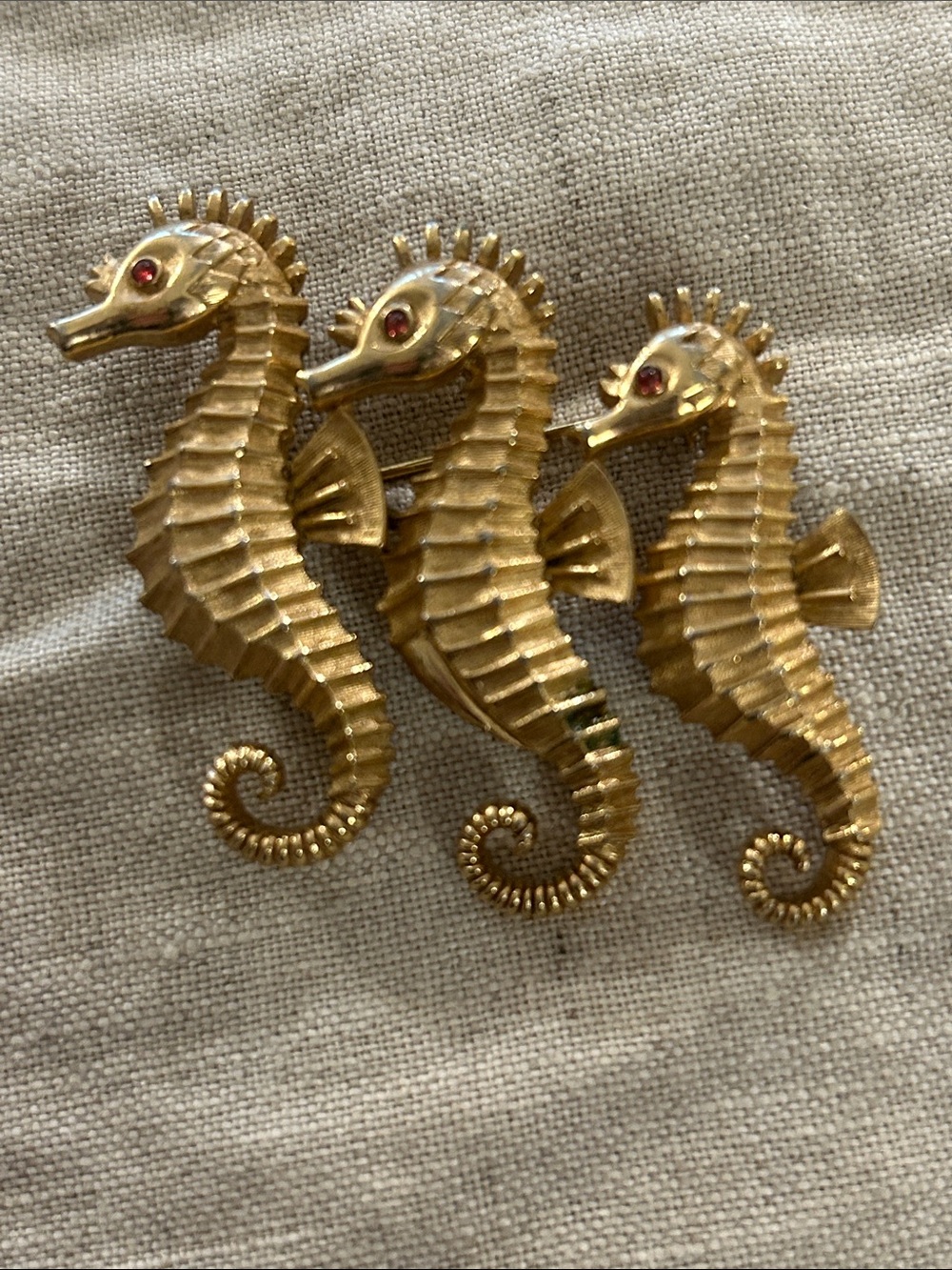Vintage Crown Trifari Gold-Tone Triple Seahorse Pin with Red Rhinestone Eyes.